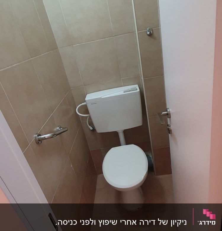 תא שירותים עם אסלה וקירות מרוצפים